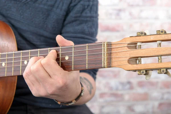 Close-up view of man's hand playing guitar — Stock Photo, Image
