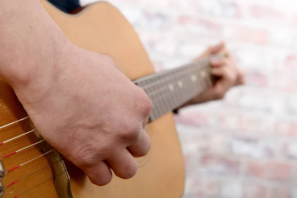 Vista de cerca de la mano del hombre tocando la guitarra —  Fotos de Stock