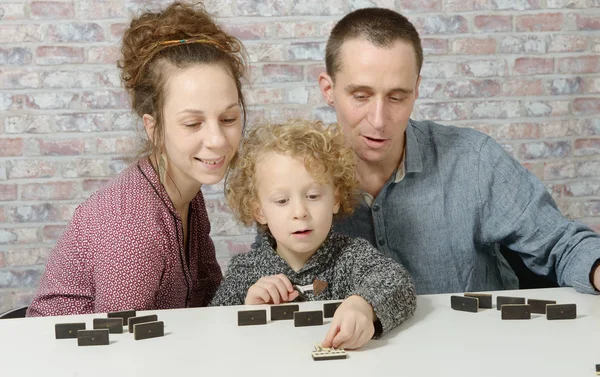 Lycklig familj spela dominos — Stockfoto