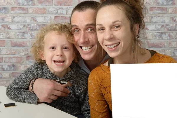 Familia feliz, la madre sosteniendo una hoja blanca de papel — Foto de Stock