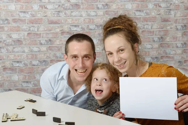 Familia feliz, la madre sosteniendo una hoja blanca de papel — Foto de Stock