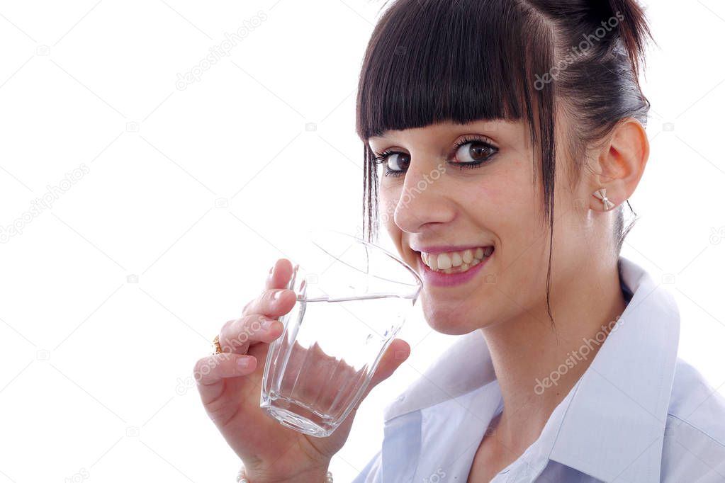 young woman drinks a glass of water, on white