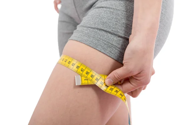 Mujer joven mide su muslo — Foto de Stock
