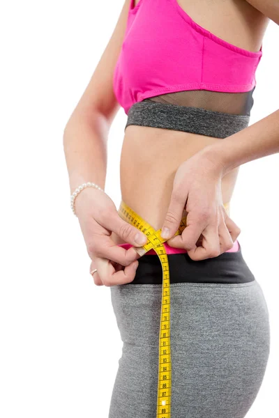 Woman measuring her waist with  measure tape on white Royalty Free Stock Photos