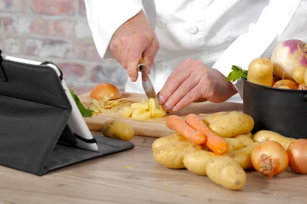Detail z rukou šéfkuchaře krájení brambor — Stock fotografie