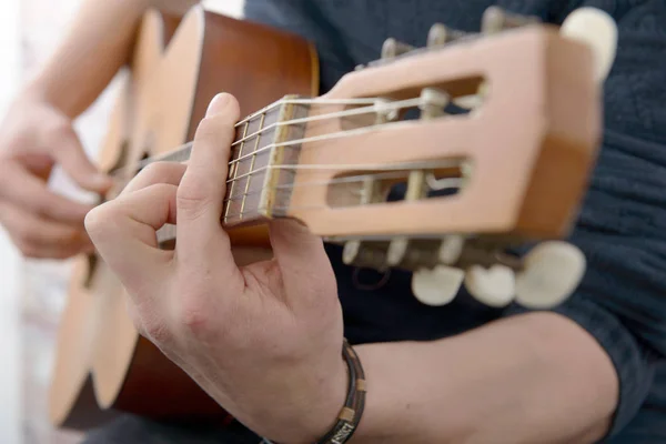 Vista de cerca de la mano del hombre tocando la guitarra —  Fotos de Stock