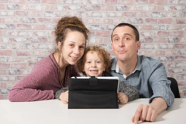 Happy family playing with a tablet computer — Stock Photo, Image