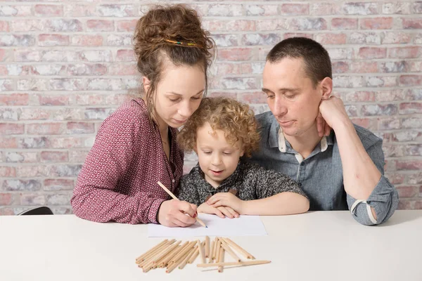 Pequeño niño rubio dibujando con sus padres — Foto de Stock