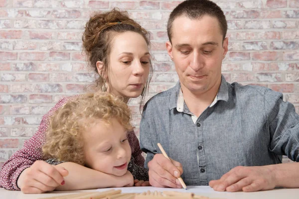 Anak laki-laki pirang kecil menggambar dengan orang tuanya — Stok Foto