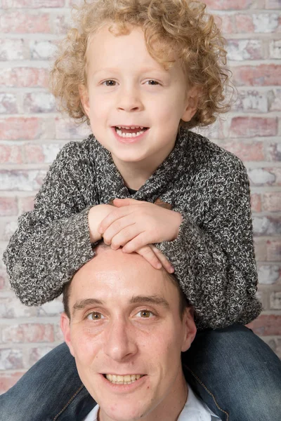 Šťastný otec nesoucí jeho syn na ramenou — Stock fotografie