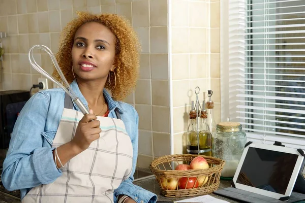 Africano mulher americana na cozinha com um computador tablet — Fotografia de Stock