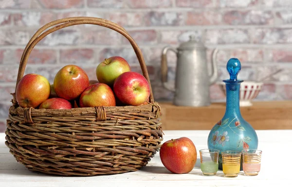 Корзина с яблоками и графином из кальвадоса — стоковое фото