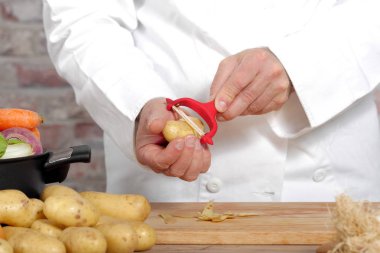 Ellerini bir adamın patates soyma ile peeling