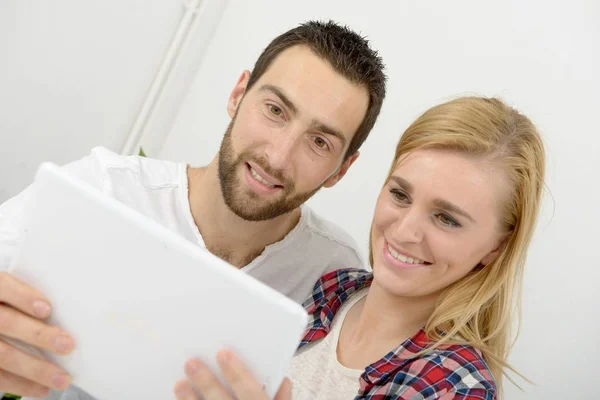 Heureux jeune couple en utilisant une tablette numérique — Photo