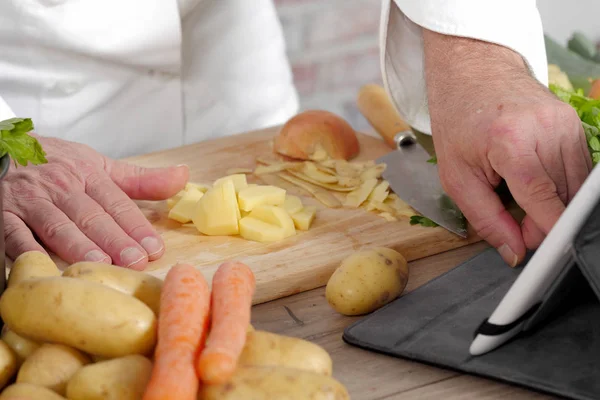 Detail z rukou šéfkuchaře pomocí tabletu pro vaření — Stock fotografie