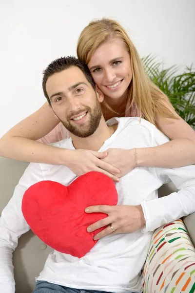 Glada unga vuxna par med rött hjärta — Stockfoto