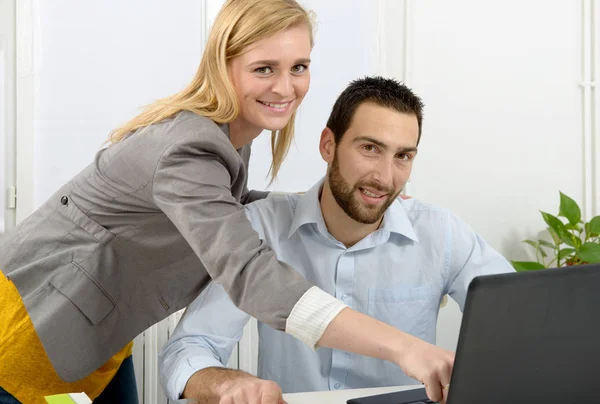Atrakcyjny mężczyzna i kobieta biznesu za pomocą komputera przenośnego — Zdjęcie stockowe