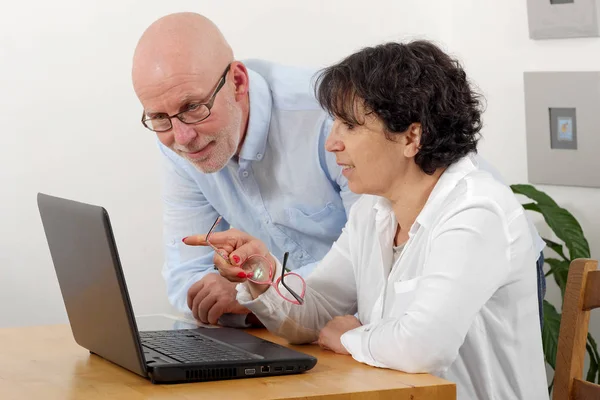 Portrait of a happy senior couple using laptop — Stock Photo, Image