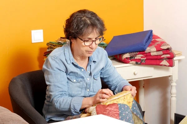 Frau näht für die Fertigstellung einer Decke. — Stockfoto