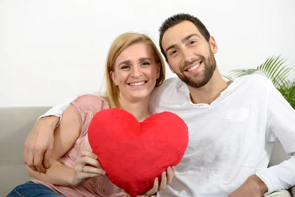 Glada unga vuxna par med rött hjärta — Stockfoto
