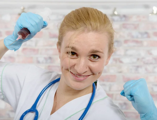 Young nurse with a big syringe — Stock Photo, Image