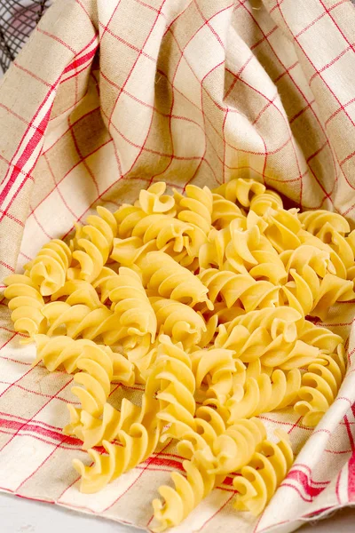 Pasta in a towel on a wooden table — Stock Photo, Image