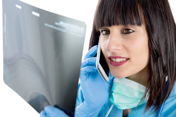 Young female doctor with stethoscope looking at patients x-ray Stock Image