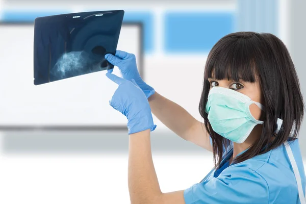 Joven doctora mirando a los pacientes rayos X — Foto de Stock