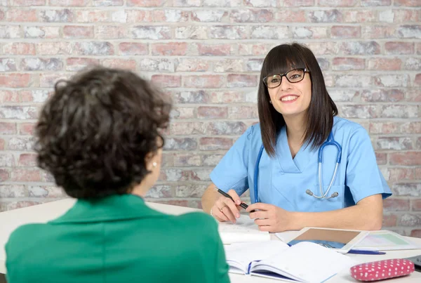 Patient having consultation with young female doctor in office — Stock Photo, Image