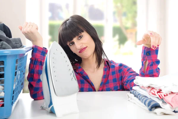 Unhappy young beautiful woman ironing clothes — Stock Photo, Image