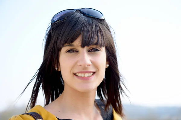 Portrét mladé brunetka s sluneční brýle, venku — Stock fotografie