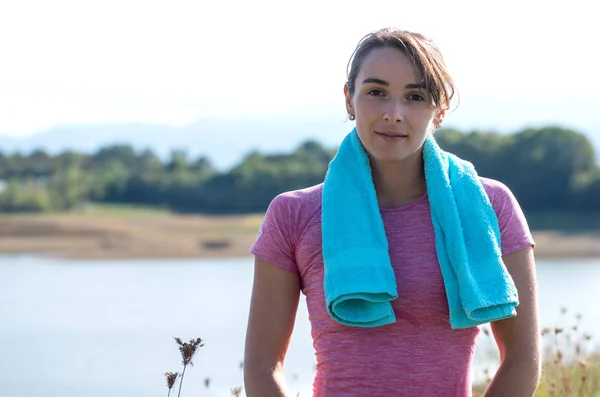 Mladá žena sportovní s modrým ručníkem na venkově — Stock fotografie