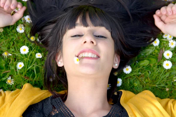 年轻的黑发女人，躺在草地上 — 图库照片