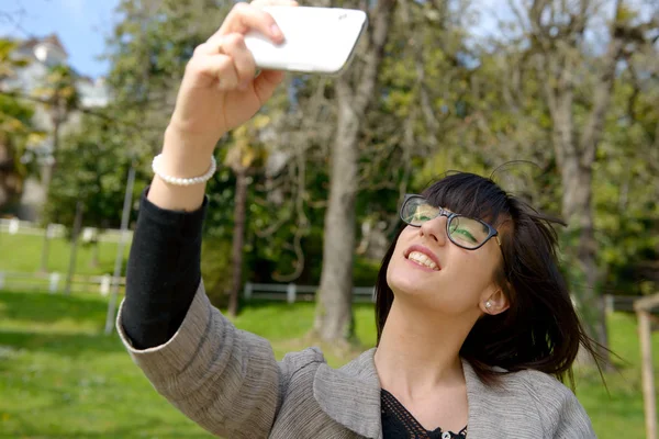 Веселая женщина делает селфи с телефоном — стоковое фото