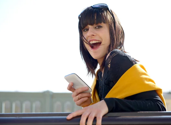 Молодая брюнетка с мобильным телефоном в парке, на открытом воздухе — стоковое фото