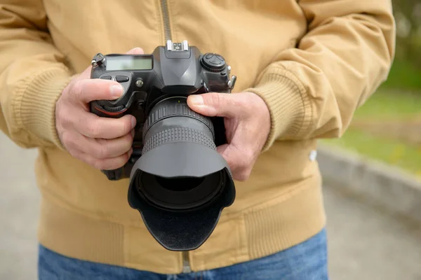 Photographer holding his photo camera — Stock Photo, Image