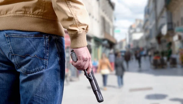 Killer man is attacking with  gun on public place — Stock Photo, Image