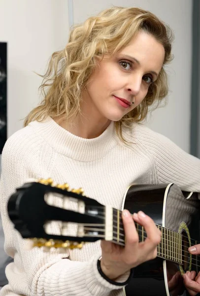 Jeune femme blonde jouant de la guitare — Photo