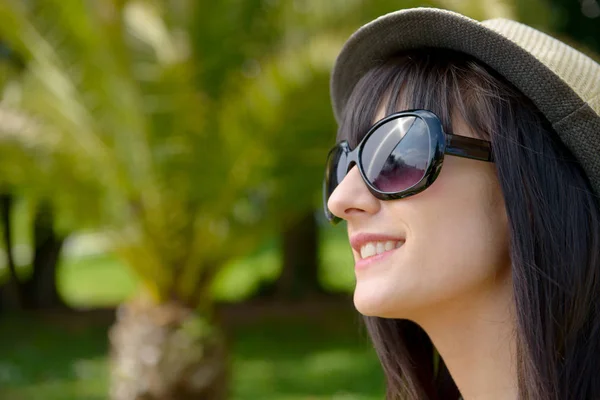 Parkta güneş gözlüklü genç esmer kadın — Stok fotoğraf