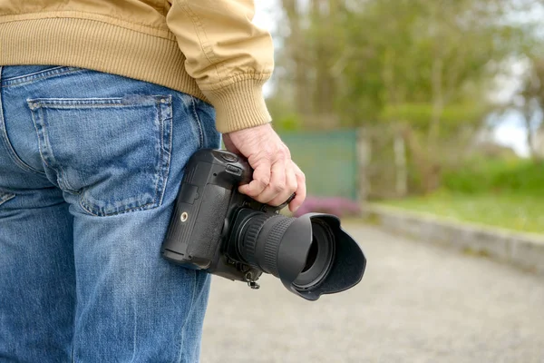 Photographer holding his photo camera — Stock Photo, Image