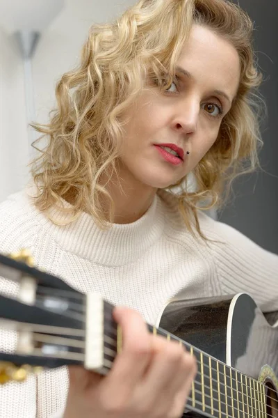 Jeune femme blonde jouant de la guitare acoustique — Photo