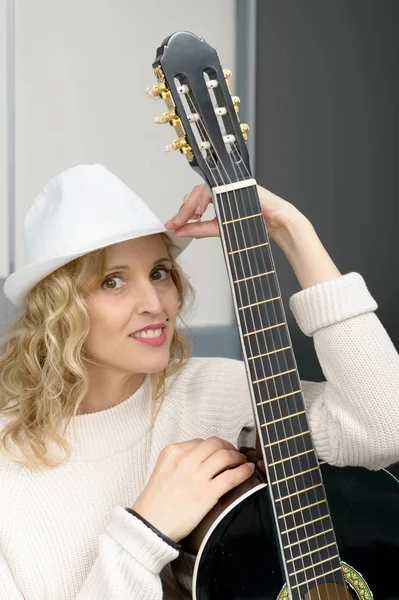 Jeune femme blonde jouant de la guitare acoustique — Photo