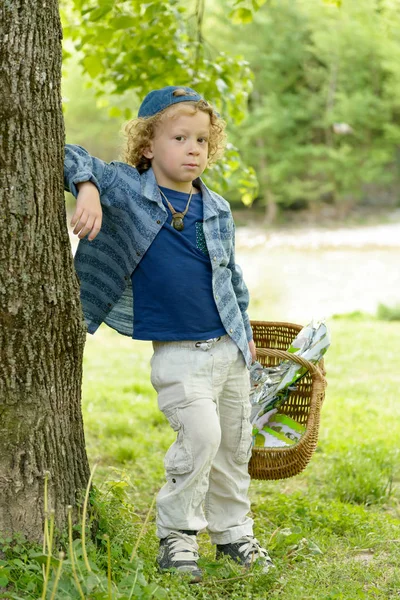 Petit garçon blond avec un panier, à l'extérieur — Photo