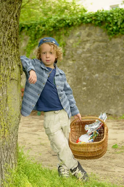 Petit garçon blond avec un panier, à l'extérieur — Photo