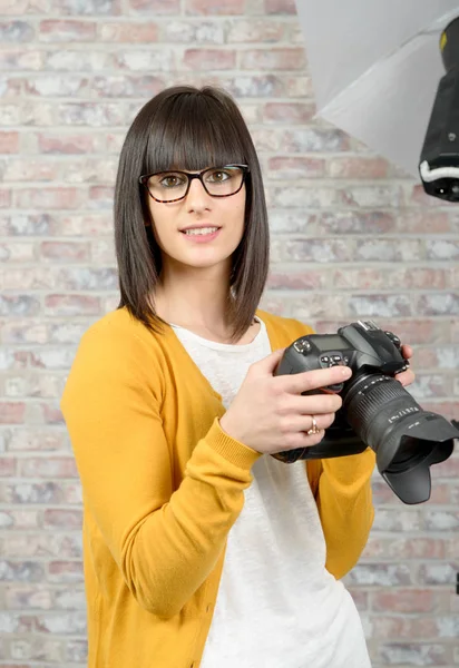 Attraktive brünette Frau mit Fotokamera im Studio — Stockfoto