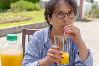 Onu bahçede portakal suyu içme kadın kıdemli