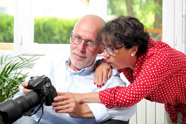 Senior couple looking at pictures on the camera screen — Stock Photo, Image