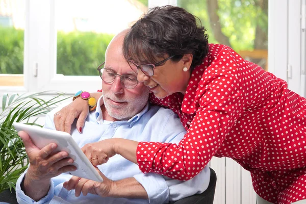 Senior couple at home using digital tablet — Stock Photo, Image