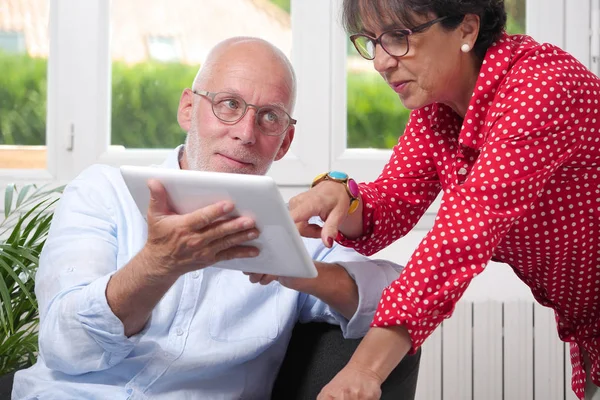 Senior couple at home using digital tablet — Stock Photo, Image