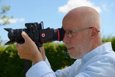 kamera dijital SLR kullanan olgun adam